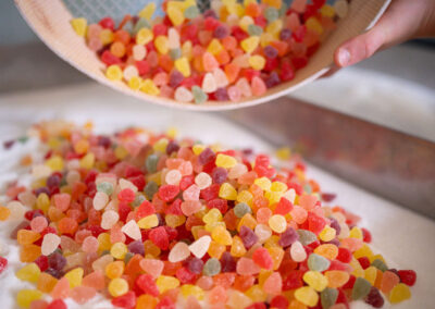 Caramelle artigianali assortite alla frutta nella foto un setaccio colmo di caramelle di gusti assortiti